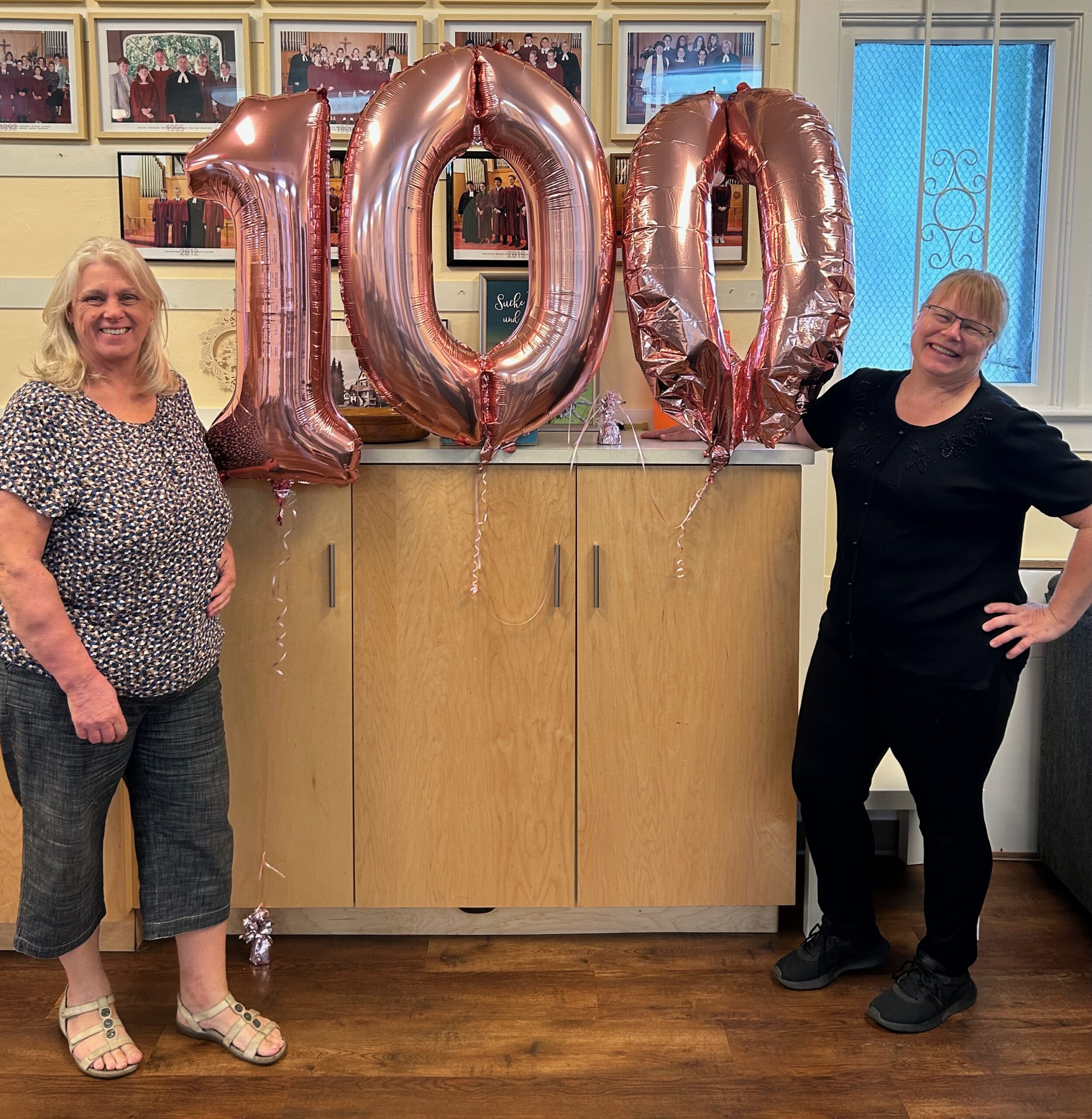 Kecia and Elke at the St. Mark's Church, posing with the "100" balloons.