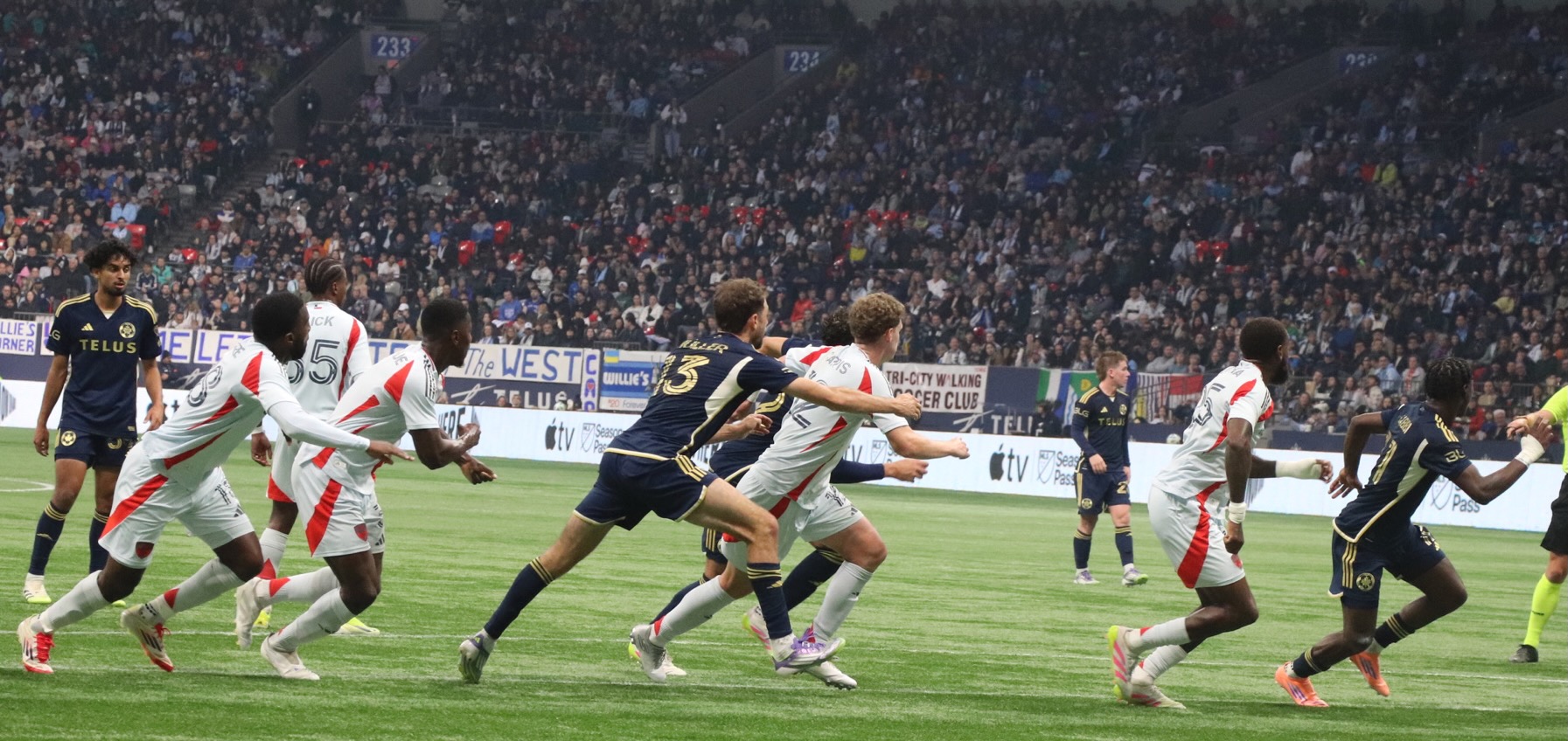 Thomas Müller fighting in the middle of a crowd of Dallas soccer players.
